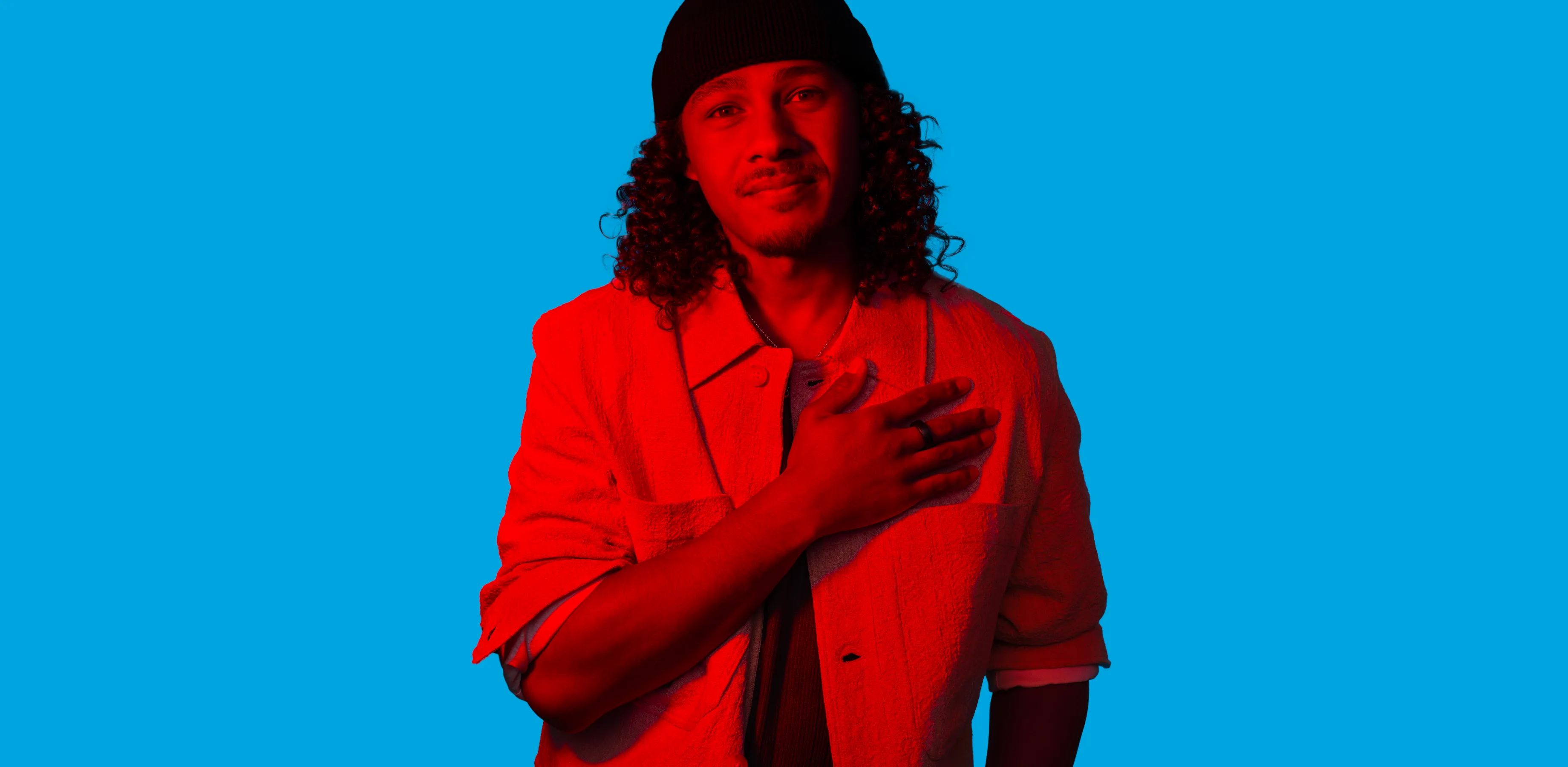 A man holds a football, and looks over his shoulder.